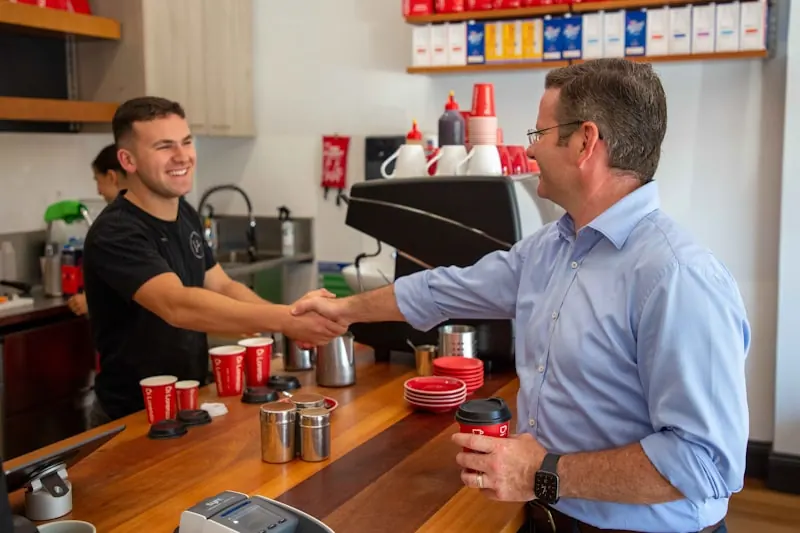 Deux professionnels se serrent la main dans un commerce pour développer une relation BtoB